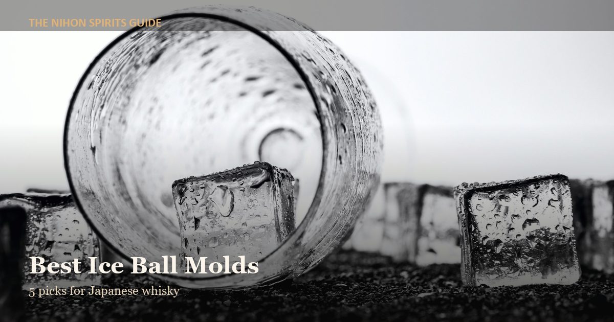 Ice cubes and a glass tumbler on a dark surface